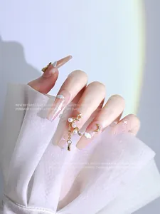 Faux ongles de luxe avec perles de zircon et breloques dorées en forme d'étoile.