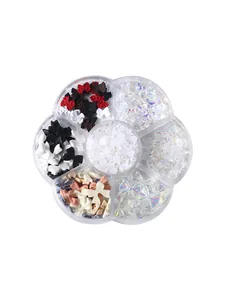 7-vaks nageldecoratieset met kleurrijke strikjes en parels in bloemvormige doos.