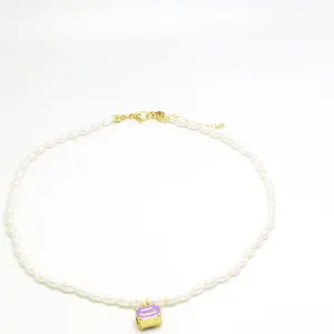 Elegant white imitation pearl necklace with a vintage purple enamel bag pendant