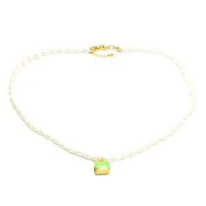 Elegant white faux pearl necklace featuring a vintage green enamel suitcase pendant