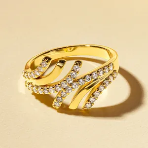 Primo piano di un elegante anello dorato con design a onde e zirconi scintillanti