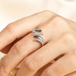 Vista dettagliata di un elegante anello d'argento ondulato con pietre su una mano.