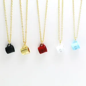 Close-up detail of colorful mini coffee cup pendants with gold chains in five shades