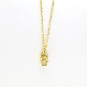 Close-up of a gold-tone necklace with a sparkling pavé flip-flop sandal pendant