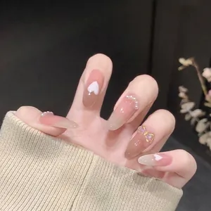 Aurora ice-clear resin nail art ornaments with heart and butterfly charms on nude nails.