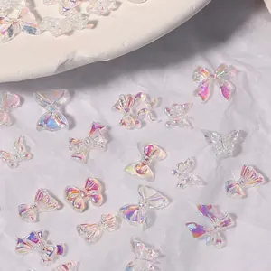 Iridescent aurora resin bow and butterfly nail art charms on a white background