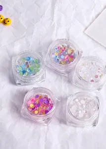 Colorful mermaid aurora nail art beads and round cat eye charms in clear glass jars.