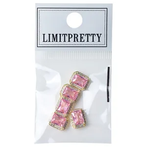Elegant pink rectangular zircon nail art rhinestones with gold borders in retail packaging