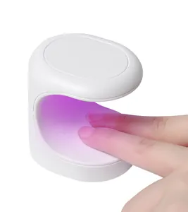 Détail d'une mini lampe à ongles UV LED portable durcissant le vernis à ongles gel