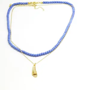 Detail view of a double-layered necklace featuring a rhinestone-encrusted slipper pendant