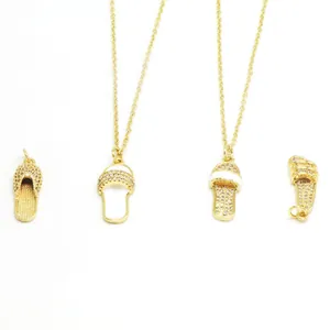 Detailed view of gold slipper necklaces with sparkling crystals and white enamel