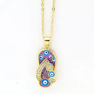 Close-up of gold necklace with purple flip-flop pendant featuring evil eye and rhinestones