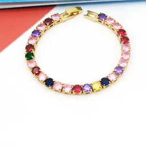 Detailopname van een levendige regenboog edelsteen tennisarmband met gouden afwerking