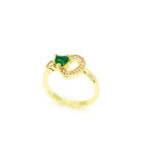 Vue détaillée d'une bague dorée ornée d'un zircon vert en forme de cœur brillant