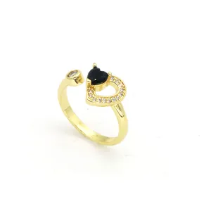 Gros plan d'une bague réglable en or avec cœur noir et pavé de zircons brillants