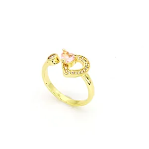 Vue rapprochée d'une bague coeur dorée avec zircon rose et micro-pavé