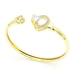 Vue détaillée d'un bracelet jonc doré élégant orné de zircons en forme de cœur.