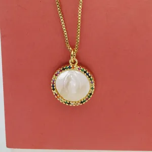 Detail view of Virgin Mary shell pendant necklace with colorful rainbow cubic zirconia