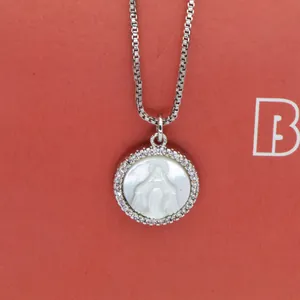 Detailed close-up view of the circular Virgin Mary shell pendant with zircon stone halo