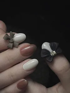 Detalle macro de lazos 3D mate para uñas en una manicura profesional estilo francés