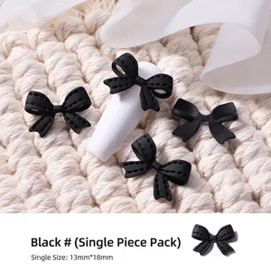 Primer plano de lazo negro mate en 3D para decoración detallada de uñas artísticas