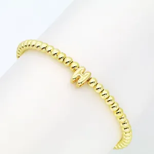 Detailansicht eines vergoldeten Perlenarmbands mit einem bauschigen H-Anfangsbuchstaben
