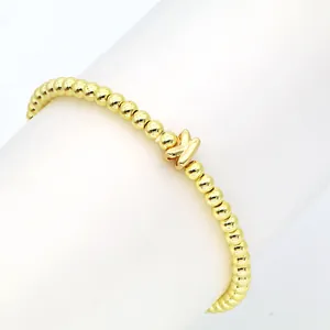 Detailaufnahme eines 18K vergoldeten Perlenarmbands mit süßem Buchstaben-K-Anhänger