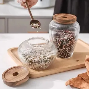 Detail view of ribbed glass storage jars with acacia wood lids and assorted grains