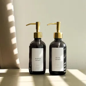 Detail of amber glass soap dispenser bottles with gold stainless steel pump heads
