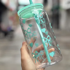 Detailansicht eines 16oz transparenten Strohhalmbechers mit minzgrünen Schleifen