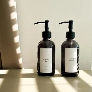 Detail view of amber glass soap dispensers with black pumps and minimalist white labels