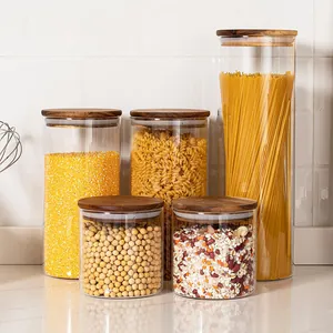 Detail shot of five airtight glass storage jars with wooden lids for kitchen organization.