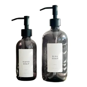 Close-up of stylish amber glass soap dispensers with black pumps and white labels