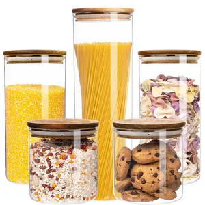 Set of 5 clear glass food storage canisters with airtight wooden lids and grains.