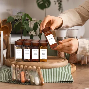 Set of glass spice jars with acacia wood lids being arranged on a wooden tray in kitchen
