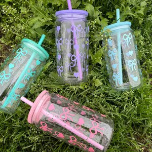 Makroansicht von 16oz transparenten Bechern mit bunten Schleifen und Herzmustern im Garten
