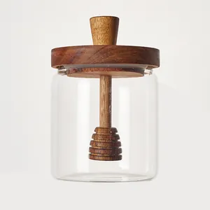 Close-up of the integrated acacia wood honey dipper inside the clear glass storage jar