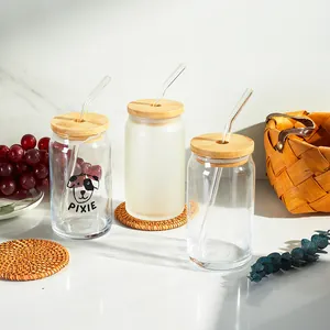 Detailed view of 16oz clear and frosted glass cans with bamboo lids and straws.
