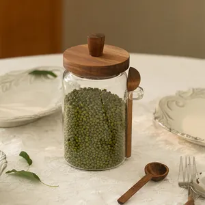 Detailed view of glass storage jar with acacia wood lid and spoon filled with beans