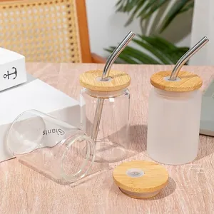 Close-up of 3.5oz clear and frosted glass cups with bamboo lids and straws