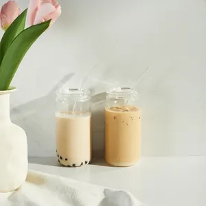 Detail view of 16oz can-shaped glass cups with straws and lids for coffee drinks