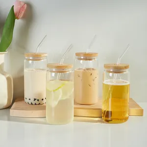 Set of four can-shaped glass cups with bamboo lids and glass straws for iced drinks