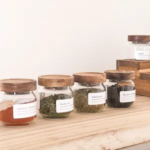 Tarros de especias de vidrio minimalistas con tapas de acacia y etiquetas.