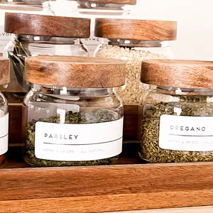 Detalle de tarros de especias de cristal con tapas de madera de acacia