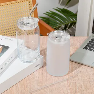 Close-up of clear and frosted can-shaped glass cups with plastic lids and glass straws