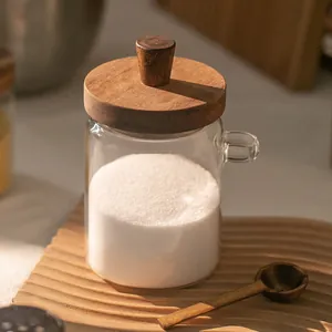 Close-up of acacia wood lid and glass jar with a wooden spoon in a kitchen setting