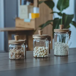 Set of glass storage jars with acacia wood lids and spoons for kitchen organization