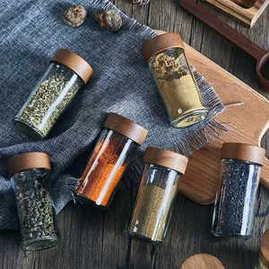 Set of 3oz round glass spice jars with natural acacia wood lids for kitchen storage.