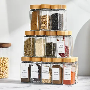 Juego de doce tarros de cristal para especias con tapas de bambú y etiquetas minimalistas.