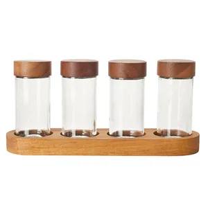 Japanese 4-piece glass spice jar set with acacia wood lids and wooden storage base.